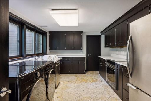 The kitchenette will make entertaining a breeze, offering rich cabinetry, expanses of workspace, plus a stove, refrigerator and dishwasher.