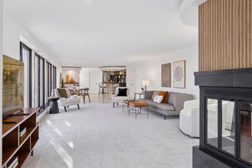 The vast family room, with new carpet in 2024 and a wall of windows to provide plenty of sunshine, is the ideal spot for game night or movie night!