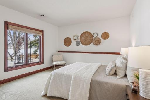 This inviting lower-level guest bedroom offers breathtaking lake views, providing a serene and luxurious retreat for your visitors.