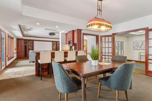 This versatile lower-level dining area flows seamlessly into the in-home gym, offering a perfect balance of fitness and dining for modern living. This space could also be used for a pool table.