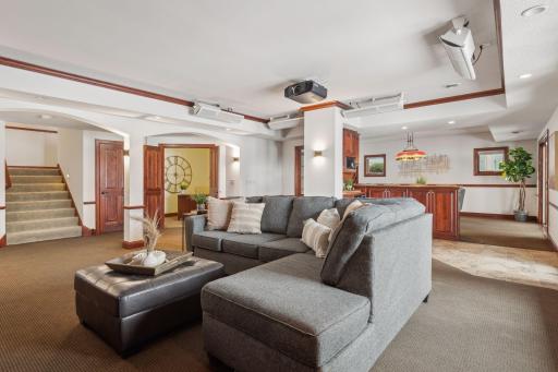 This expansive open-concept lower level seamlessly flows into an adjoining bar, creating the perfect setting for entertaining, relaxation, and memorable gatherings.