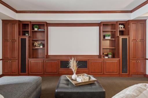 This stylish lower-level entertainment area features custom cabinetry, offering both function and flair for the perfect space to relax and entertain.