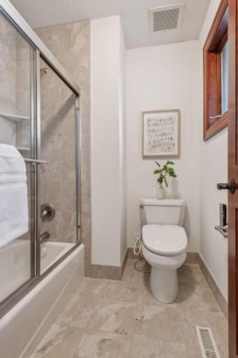 This modern powder bath features a stylish walk-in shower, blending sleek design with functionality for a truly refined space.