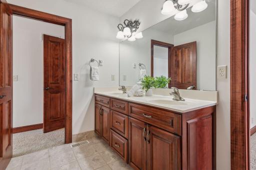 This beautifully appointed upper-level bath features a sleek two-sink vanity, high-end finishes, and a spacious, serene ambiance for ultimate relaxation.