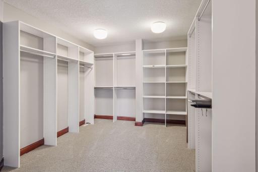 This primary suite walk-in closet offers abundant storage with custom organizers, perfect for keeping everything beautifully arranged.