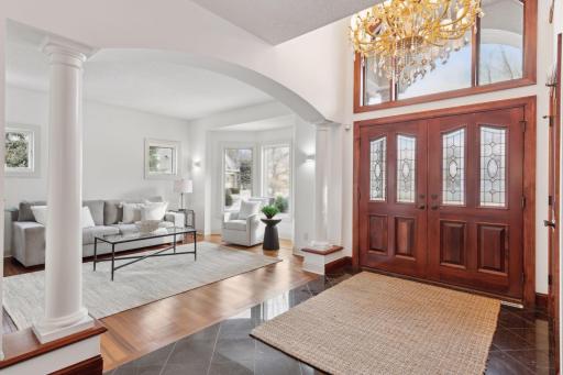 Enter this stunning home through solid wood doors with intricate lead glass inlays, and be welcomed by an expansive entry foyer featuring a beautiful chandelier. The space seamlessly flows into the open-concept living area.