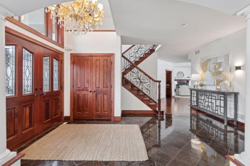 Step into luxury through these stunning solid wood double doors, opening to an expansive entry foyer with stone tile flooring and a convenient entry closet. The perfect blend of elegance and functionality awaits!