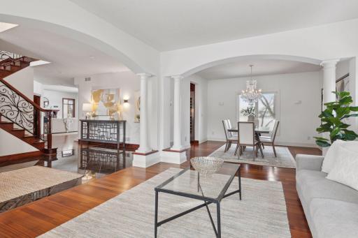 Step into the luxurious main-level living room, where grand arches and elegant architectural details frame the view into a sophisticated formal dining space. Perfectly designed for upscale living and seamless entertaining.