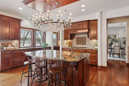 At the heart of this open kitchen, a large center island with ample seating invites gathering and conversation, offering both a functional workspace and a stylish focal point for the room.