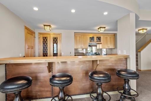 Full bar with wine cellar and extra storage space to the left with smaller garage door to the front yard. Great space to store your bikes and lawnmower