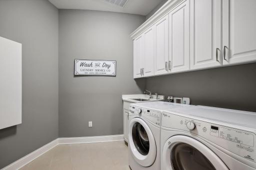 Main level laundry with storage, sink, iron closet