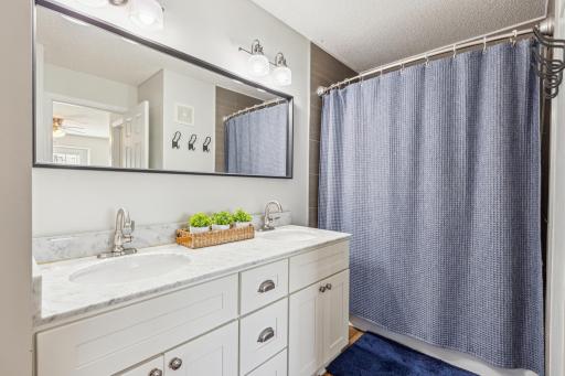 Updated bathroom w Luxury vinyl plank flooring, double sinks, storage closet and ship lap details
