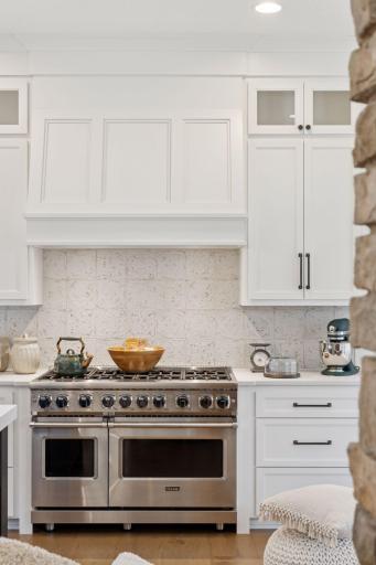 Sleek white cabinetry with gourmet gas stove