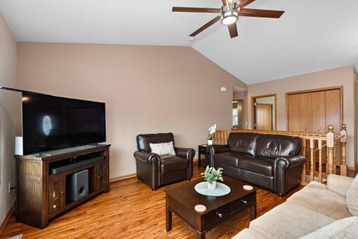 Main Floor Living room has vaulted ceilings, newer ceiling fan, newer flooring, views to back yard and sliding glass door to deck with steps to back private yard!