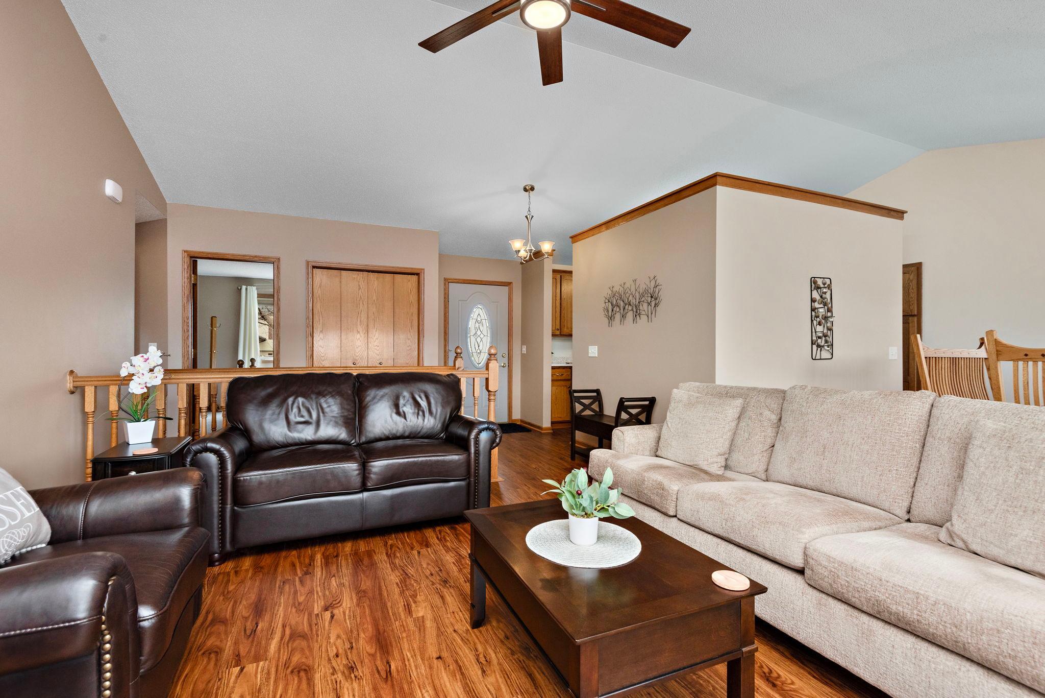 Main Floor Living room has vaulted ceilings, newer ceiling fan, newer flooring, views to back yard and sliding glass door to deck with steps to back private yard!