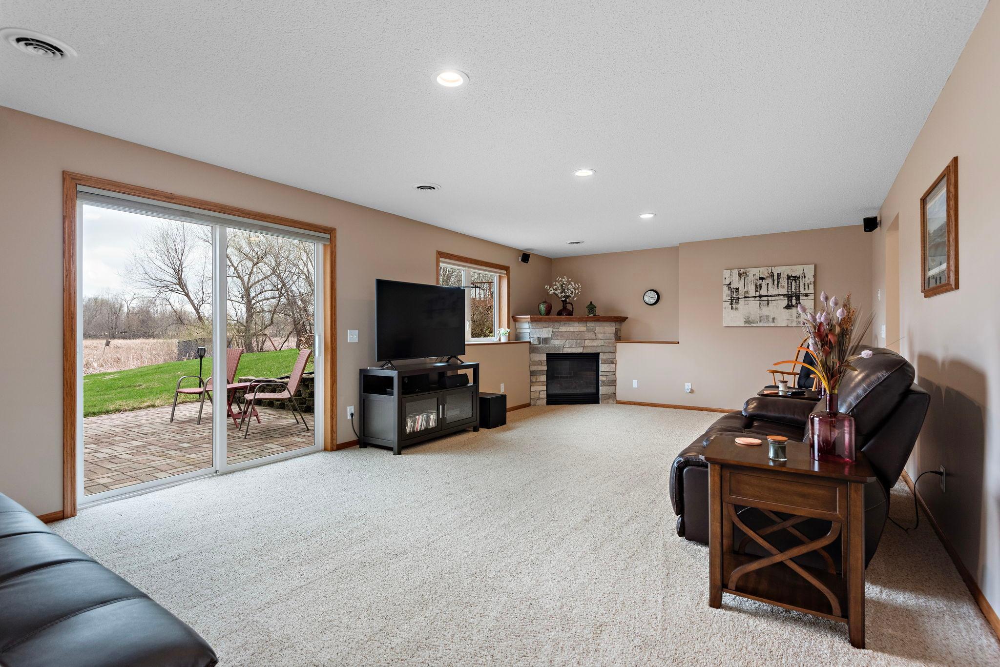 Beautiful lower level Family Room has corner gas fireplace, LED lighting and walks out to patio - outside wiring for your future hot tub!