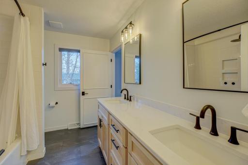The completely remodeled main bath offers modern fixtures, finishes, and double vanities, while the updated lower-level bath adds extra convenience.