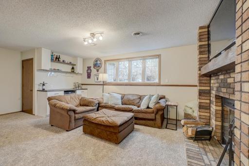 The lower level features a cozy wood-burning fireplace and a newly added bar, making it an ideal space for entertaining or unwinding.
