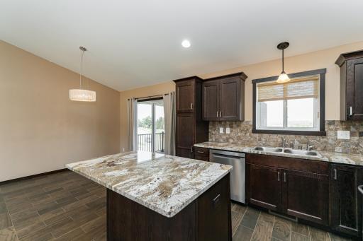 Kitchen with granite tops, tiled backsplash and SS appliances