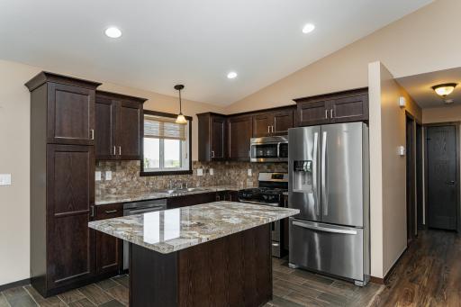 Kitchen with granite tops, tiled backsplash and SS appliances