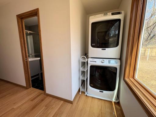 Main level laundry next to 3/4 bath in primary suite