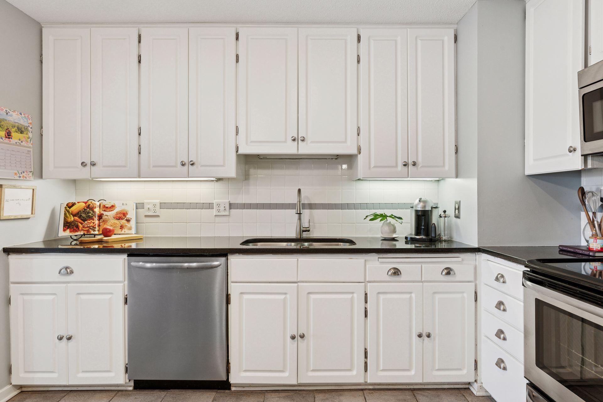 Pretty white cabinetry, granite countertops, neutral backsplash and stainless appliances.