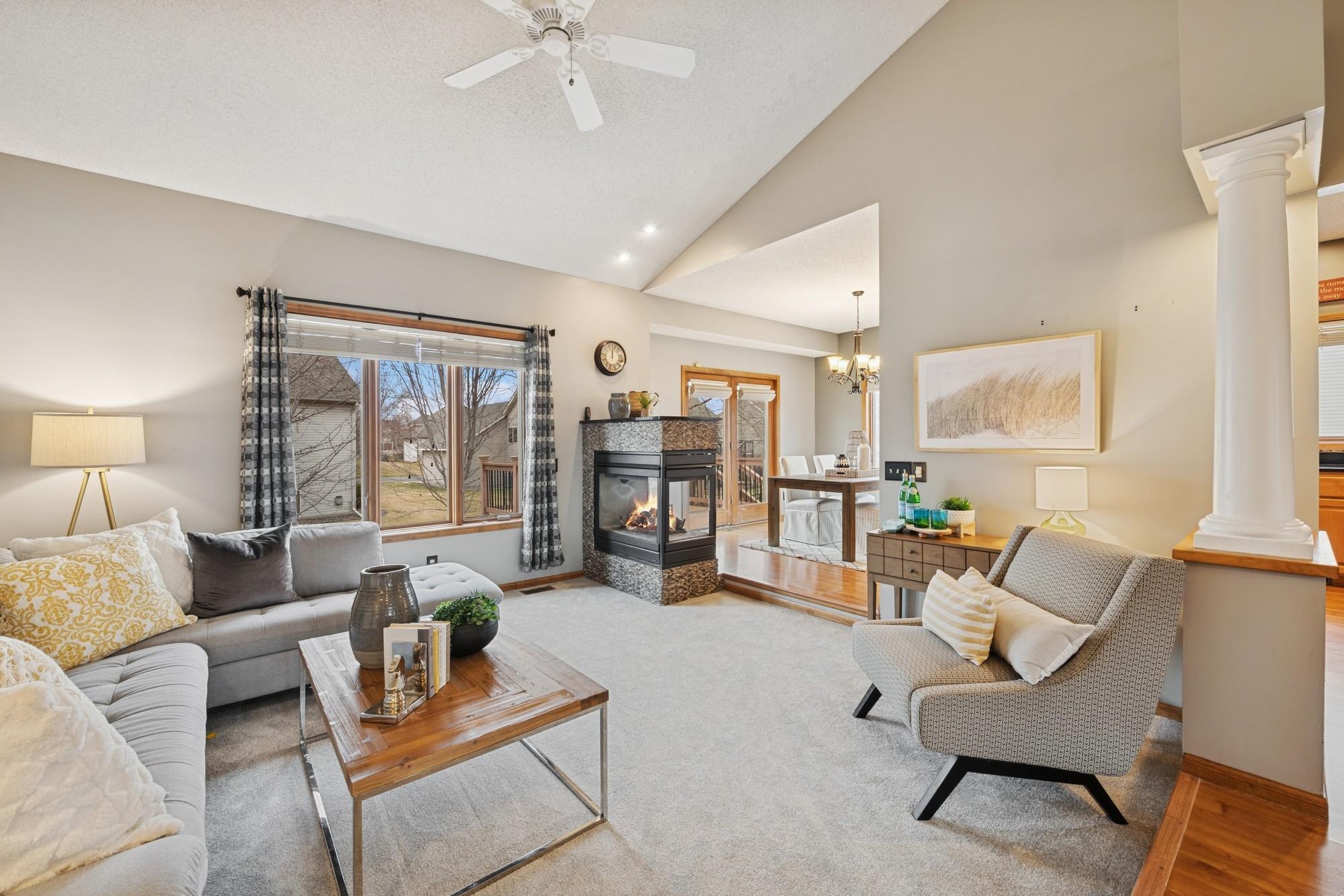 Spacious vaulted living room with see through gas fireplace
