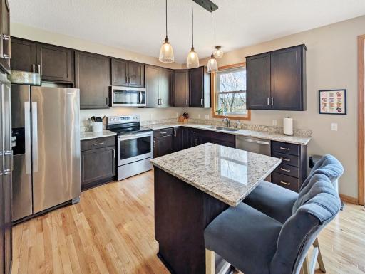Warm, hanging light fixtures pull this kitchen together as a cozy space to not only make food, but also to visit with others.