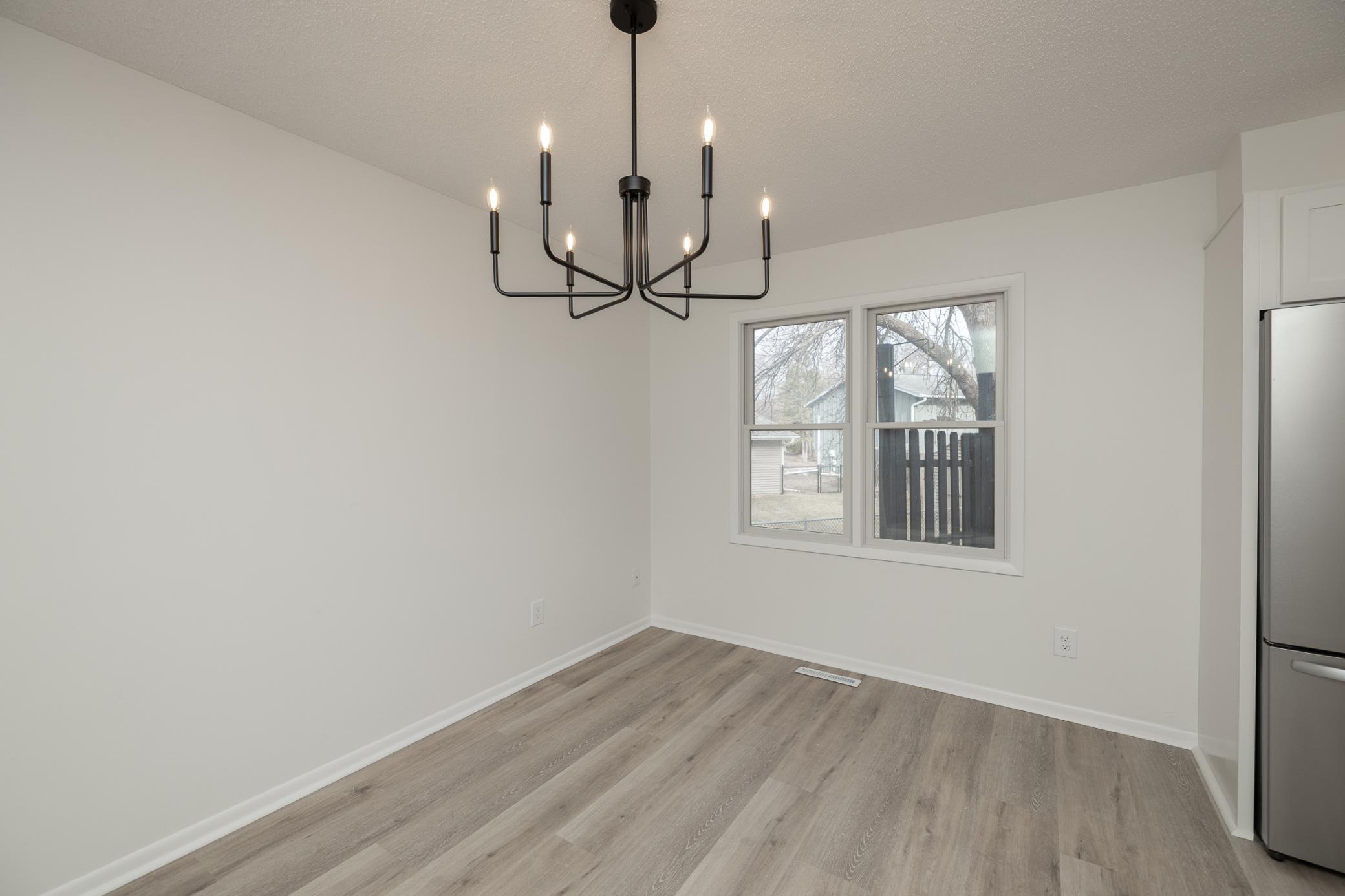 Dining room with new LVP flooring, lighting and fresh paint