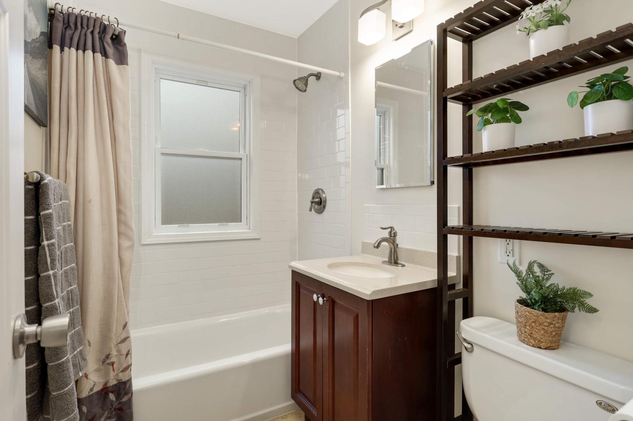 Bright and clean main floor bathroom featuring classic finishes, offering convenient access just steps from the bedroom and living area.
