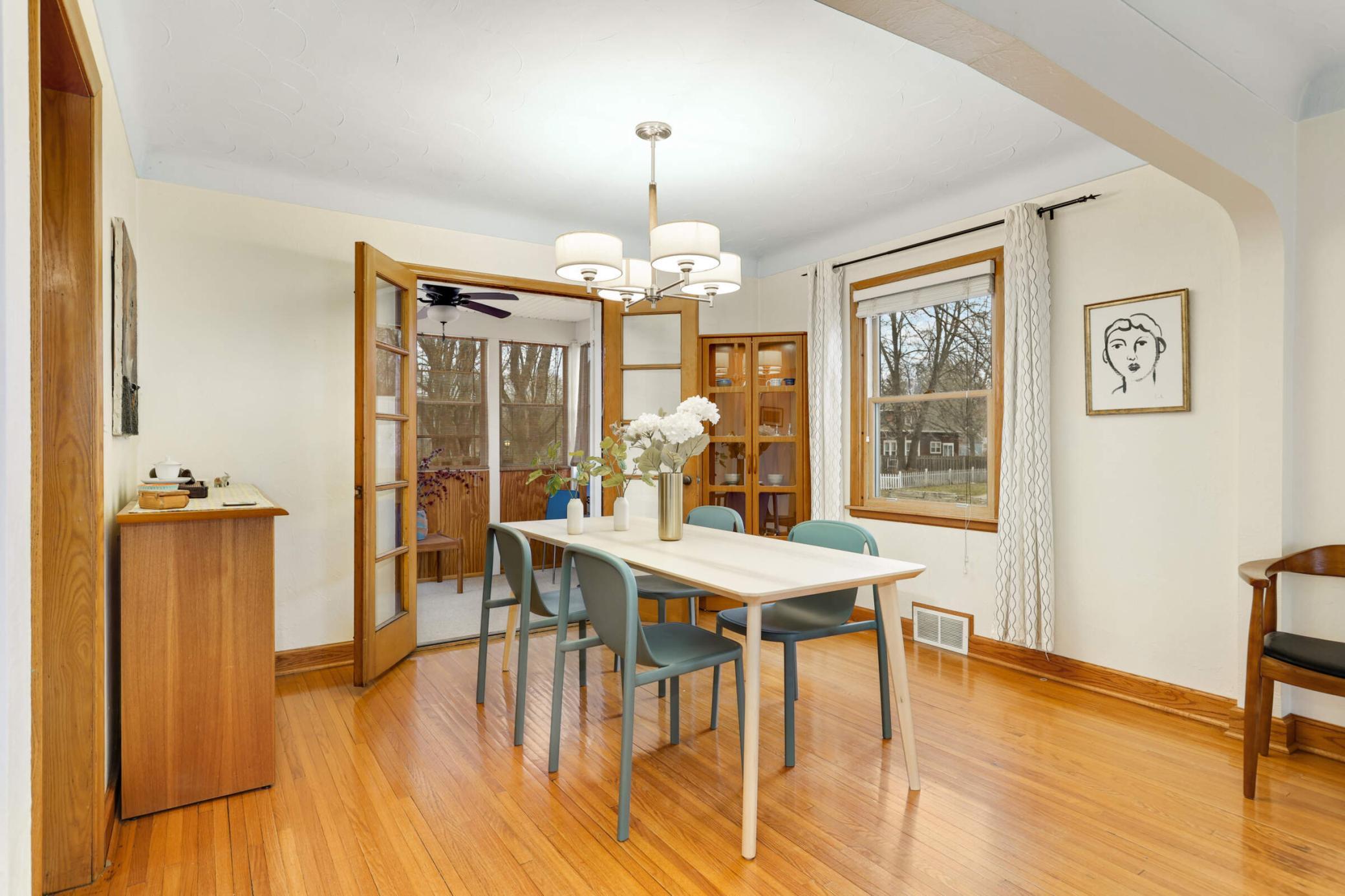 Bright and open informal dining area highlighted by a modern light fixture and sun-filled window—perfect for everyday meals or hosting guests.