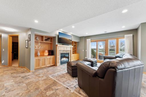 Walkout family room is spacious yet cozy with a gas fireplace, in - floor heat, wall of windows and new sliding door.