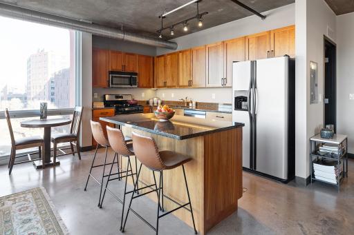 Kitchen with granite countertops, stainless steel appliances, island, and lots of cabinet space.