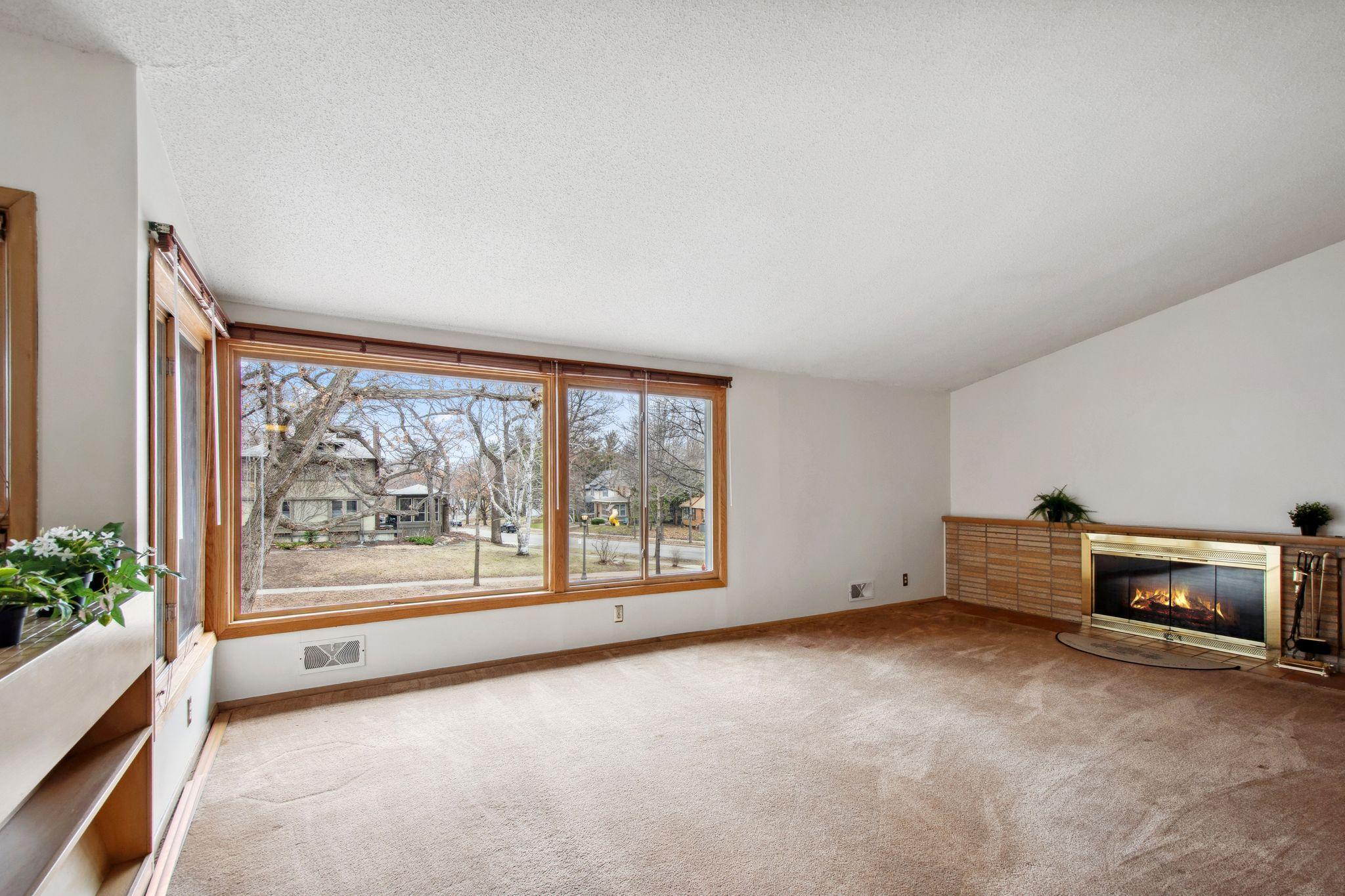 This living room has an amazing view out the window and a wood burning fireplace.