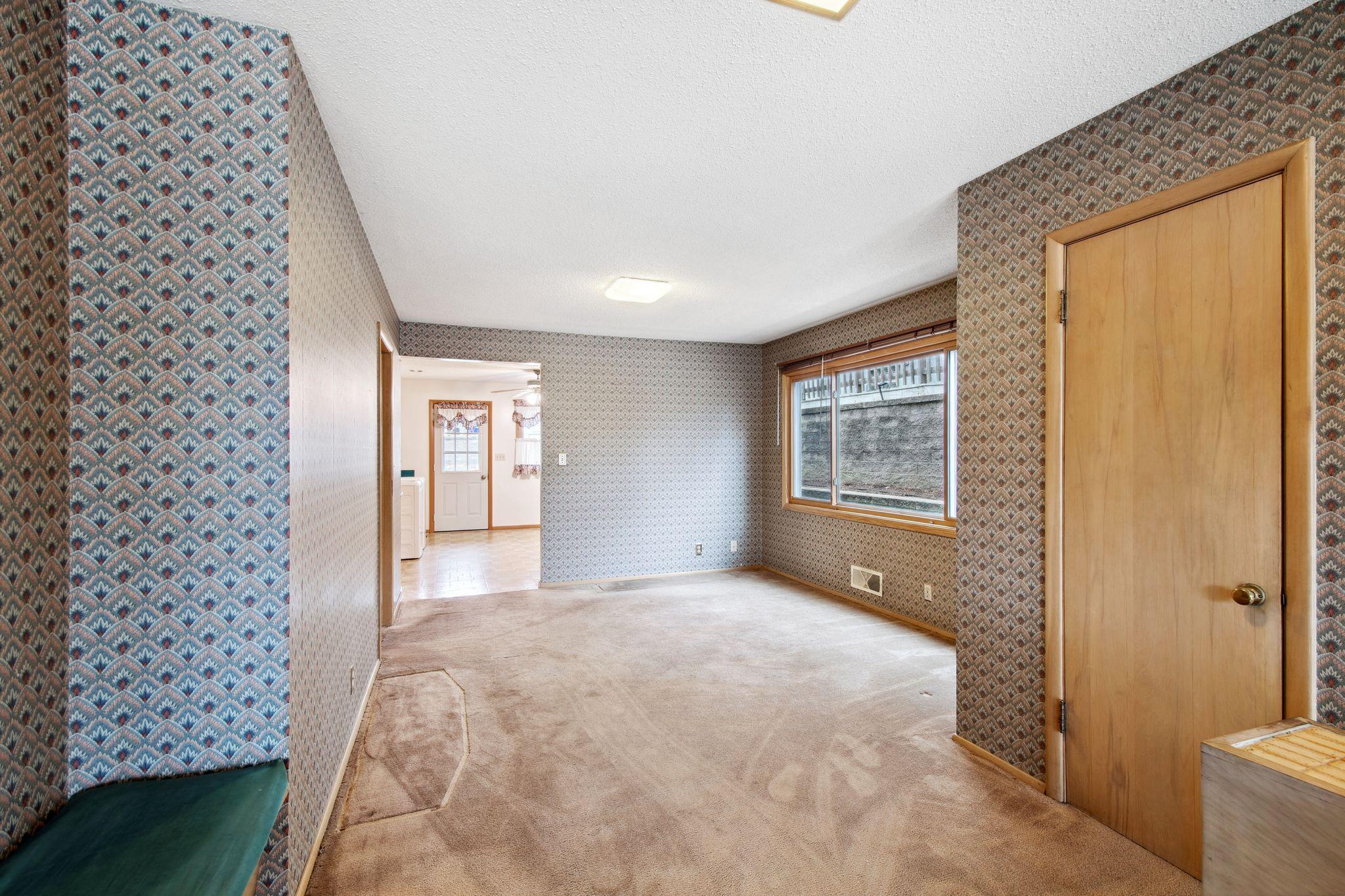 View of dining room with a coat closet on the right and bench on the left.