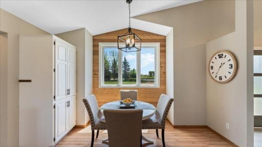 Small dining area in kitchen with new light fixtures and wood paneling coordinating with the homes' style