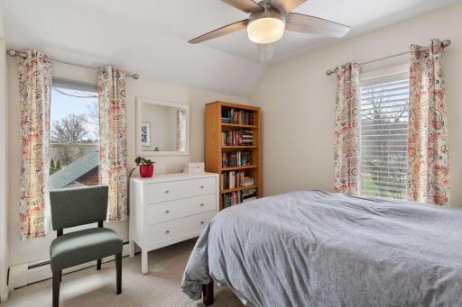 2nd of two upper level bedrooms featuring 2 windows, carpeted floor, double closet and ceiling fan with light.