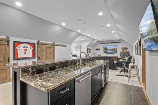 Extensive wet bar includes sink, fridge and dishwasher. Spill safe flooring is an added bonus!