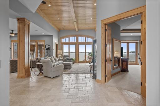 Tile floors and custom wood ceilings carry straight to the lake views