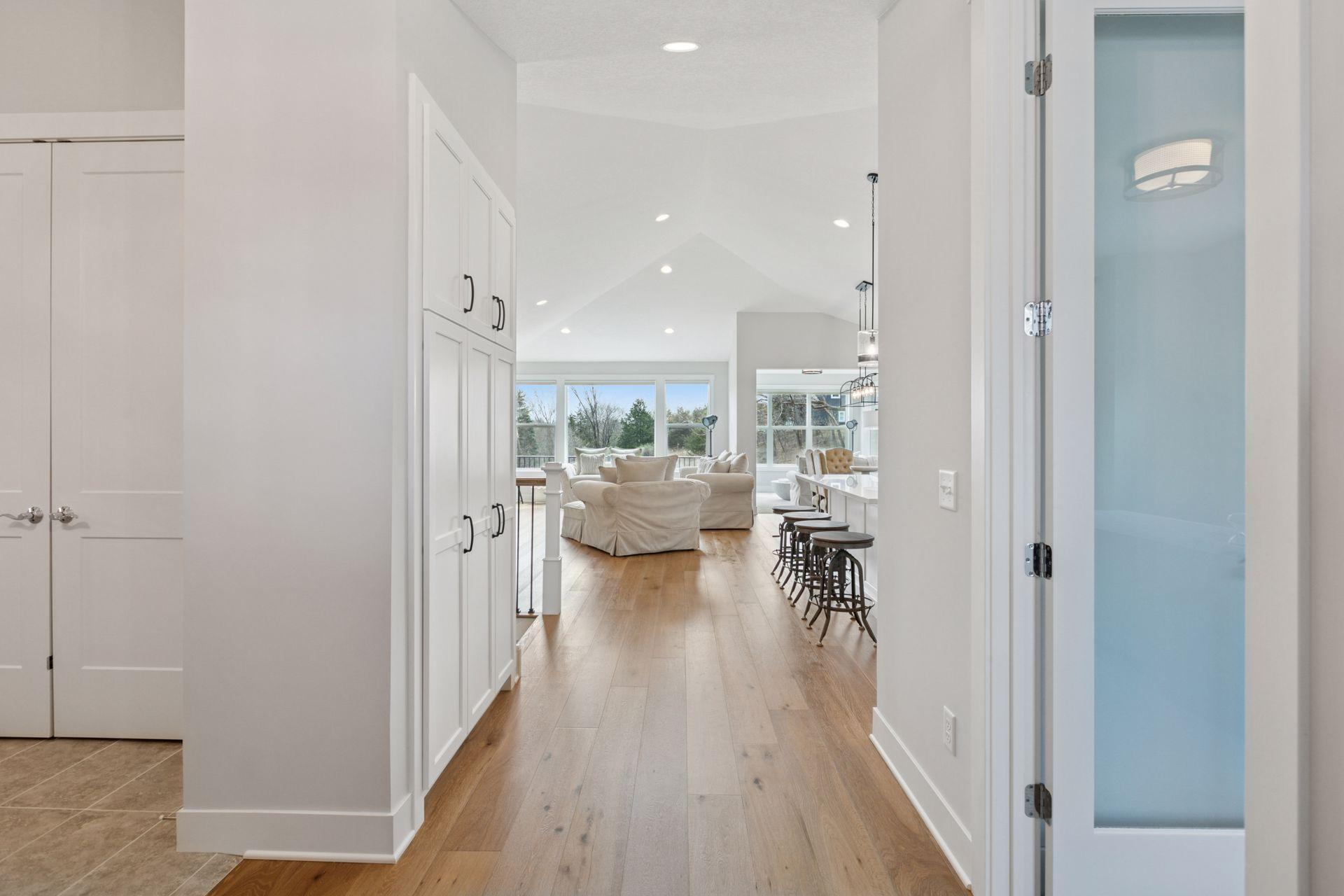 Bright and inviting entry view with sunlight streaming through large picture windows.