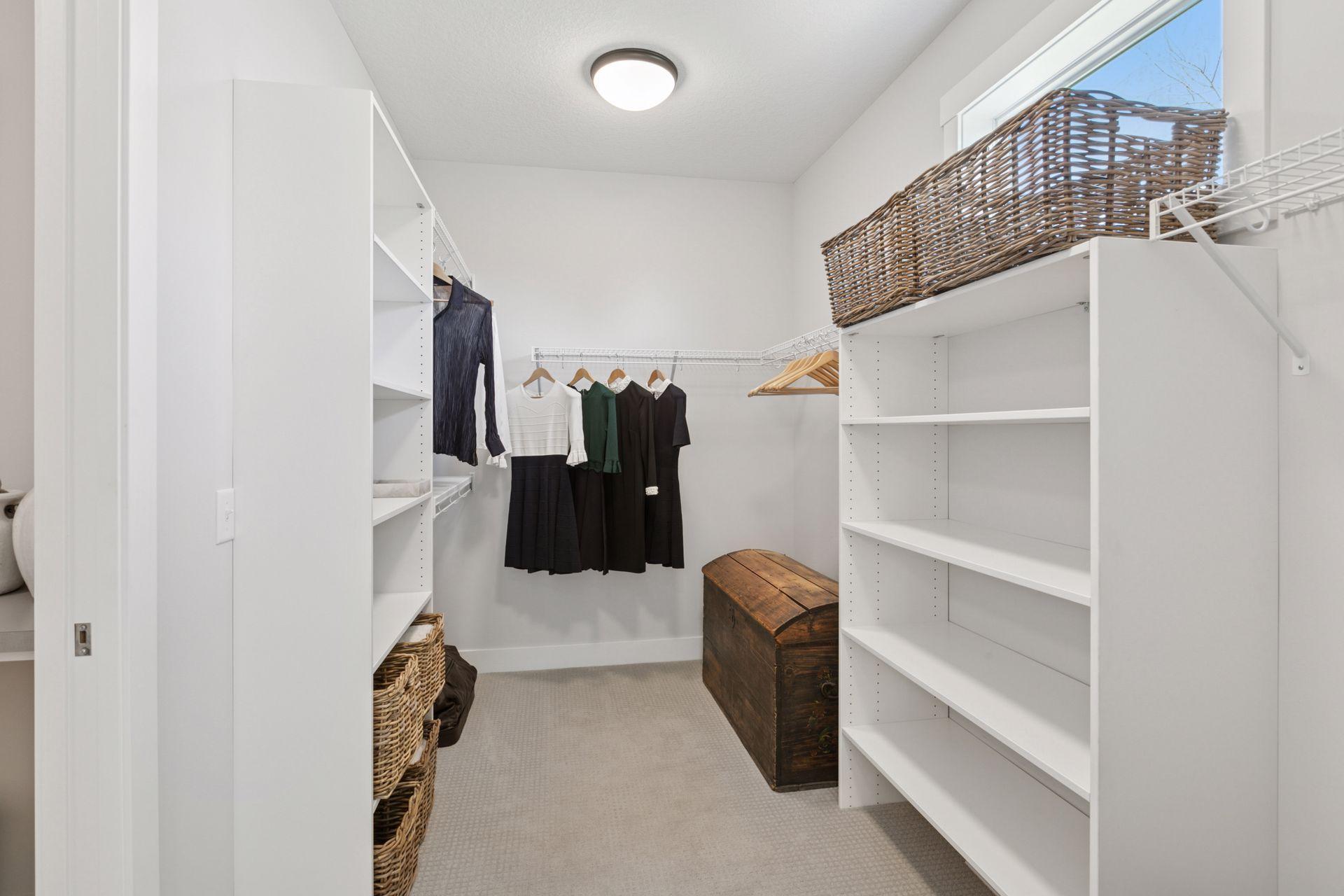 Primary suite walk-in closet with direct access to the laundry room.