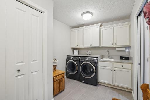 The laundry area features a washer and dryer with overhead cabinetryâoffering plenty of storage and a clean, efficient space for everyday tasks.