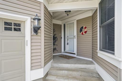 Charming covered entry with detailed trim work offers a warm welcome and a hint of the quality finishes you'll find throughout this custom-built home.