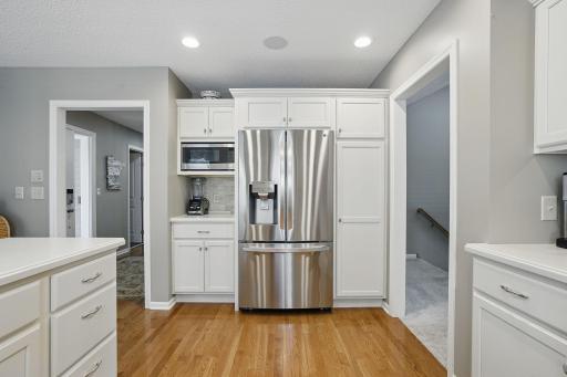 From the entryway, youâre greeted with a view of this beautifully updated kitchenâshowcasing recessed lighting, white cabinets, and thoughtful design.