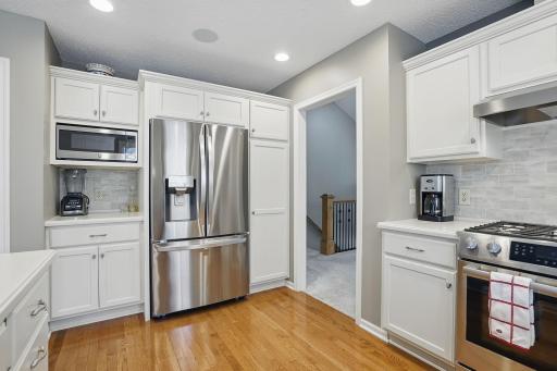 A newer LG refrigerator (2023) anchors this wall of cabinetry, offering tons of storage with soft-close drawers and under-cabinet lighting.