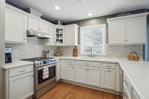The kitchen features a gas range and a glass-front corner cabinetâadding both function and charm.