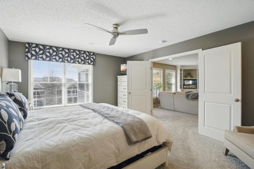 Looking out from the ownerâs suite, the French doors open to the main living areas, showcasing the open layout and inviting flow between the private and shared spaces.