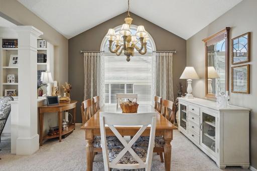 An elegant column frames the transition from the vaulted dining room to the living room, adding architectural interest and highlighting the open, yet defined, layout of the main living space.