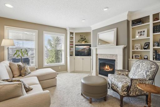 Cozy and refined, the living room features a gas fireplace framed by custom built-ins and detailed crown moldingâshowcasing the craftsmanship and warmth of this custom-designed home.
