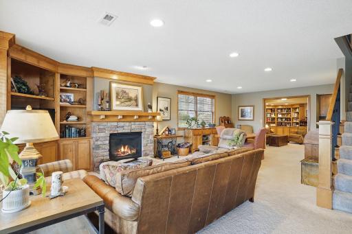 This warm and inviting lower level features a gas fireplace with custom built-ins, recessed lighting, and an open layout that flows into a versatile spaceâperfect for a game table, crafts, or casual entertaining.